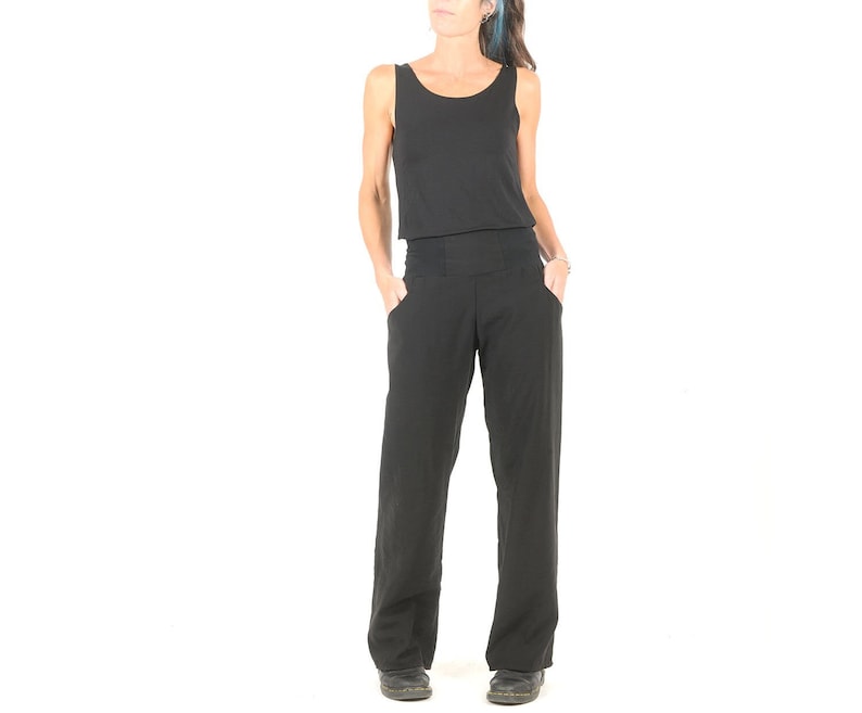 May include: A black sleeveless jumpsuit with a wide leg. The jumpsuit has a fitted bodice and a wide waistband.