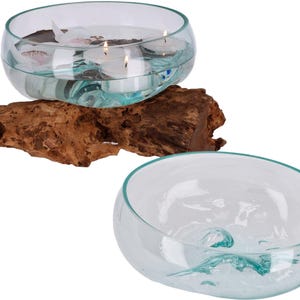 Könnte beinhalten: Zwei klare Glasschalen mit wellenförmigen Rändern, eine auf einem Stück Treibholz. Die Schale auf dem Treibholz hat Wasser und drei schwimmende Kerzen darin.