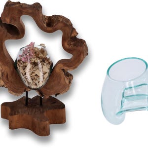 May include: A decorative wooden stand with a natural, rustic look, featuring a glass vase with dried flowers and wood pieces. The stand is shaped like a heart and has a natural wood finish.