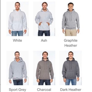 May include: A selection of hooded sweatshirts in various colors, including white, ash, graphite heather, sport grey, charcoal, and dark heather. Each sweatshirt features a drawstring hood and a front pocket. The colors are displayed with a person wearing each sweatshirt.