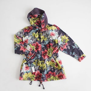 May include: A hooded jacket with a floral print featuring pink, yellow, and blue flowers on a dark purple background.