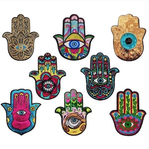 以下が含まれることがあります： さまざまな色とデザインの8つのハムサハンドパッチのコレクション。各パッチは、複雑なビーズ細工と目のシンボルを特徴としています。カラーパレットには、金、青、ピンク、緑、黄色が含まれており、詳細なパターンとテクスチャがあります。