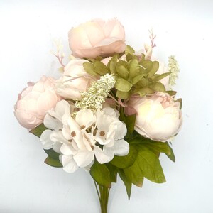 May include: A bouquet of artificial flowers with pink peonies and white hydrangeas. The bouquet is accented with green leaves and small white flowers.