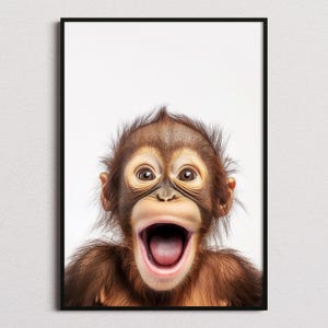 May include: A framed wall art print featuring a close-up portrait of a young orangutan with brown fur and a wide-open mouth, set against a plain white background. The primate has dark eyes and light-colored skin around its nose and mouth.