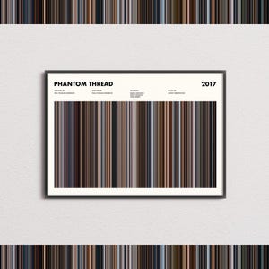 May include: A framed horizontal poster titled Phantom Thread 2017 featuring a central graphic composed of vertical color stripes in shades of brown, black, grey, and cream. The text includes credits for director, writer, starring cast, and music.