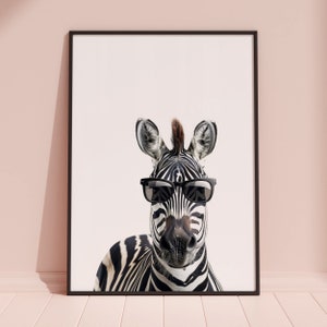 May include: A black and white zebra wearing sunglasses. The zebra has a black and white striped pattern and is looking directly at the camera. The background is white.