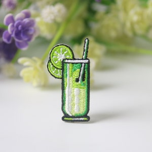 Może przedstawiać: Zielona haftowana naszywka z zielonym limonkowym szklanką z plasterkiem limonki i słomką.
