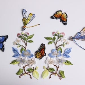 May include: Embroidered patches of butterflies, dragonflies, and floral designs. The patches feature blue, orange, yellow, and white colours. Ideal for customising clothing or accessories with a nature theme.