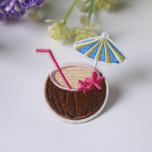 May include: Embroidered iron-on patch of a brown coconut with a pink flower, a yellow straw, and a blue and yellow striped umbrella.