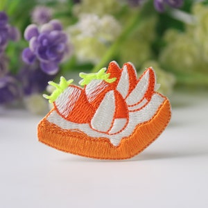 Può includere: Toppa ricamata arancione e bianca da stirare a forma di fetta di torta di zucca con gambo verde.