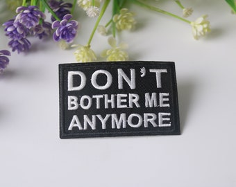 May include: Black embroidered patch with white text that reads "DON'T BOTHER ME ANYMORE".