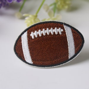 Puede incluir: Parche bordado de color marrón y blanco para planchar, con forma de balón de fútbol americano.