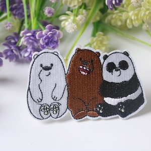 Puede incluir: Tres parches bordados para planchar con los personajes de la caricatura "We Bare Bears". Los parches son blancos con contornos negros y muestran a Ice Bear, Grizzly y Panda.