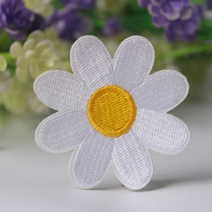 Puede incluir: Parche de flor de margarita de fieltro blanco con un centro amarillo. El parche es perfecto para agregar un toque de fantasía a la ropa, las bolsas u otras manualidades.