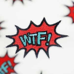 May include: Embroidered patch with a red burst design and the text "WTF!" in teal. The patch has a black border and is likely for clothing or accessories. Several patches are visible against a white background.