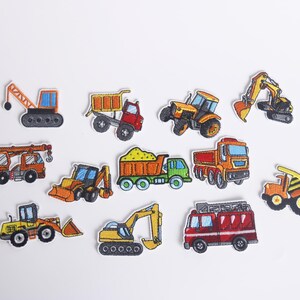 May include: A set of ten colorful iron-on patches featuring different types of construction vehicles, including a crane, dump truck, bulldozer, excavator, and a fire truck.