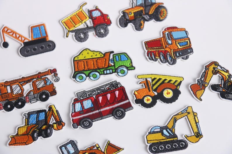 May include: A set of ten iron-on patches featuring various construction vehicles, including a crane, dump truck, excavator, fire truck, and bulldozer. The patches are colorful and detailed, with embroidered designs.