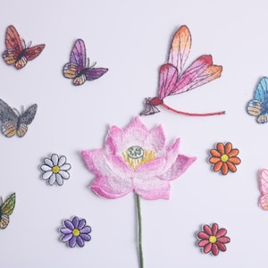 May include: A collection of embroidered iron-on patches featuring a pink lotus flower, a dragonfly, butterflies, and daisies. The patches are ideal for adding a touch of whimsy to clothing, bags, or other fabric items.