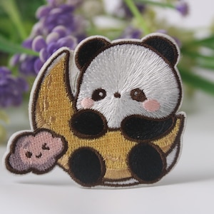Puede incluir: Parche bordado para planchar con un lindo oso panda sosteniendo una luna creciente con una nube. El panda es blanco con orejas, ojos y patas negras. La luna es amarilla y la nube es rosa.