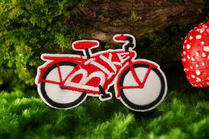 K&ouml;nnte beinhalten: Roter gestickter B&uuml;gelaufkleber mit einem Fahrrad, auf dem das Wort "BIKE" in Wei&szlig; auf dem Rahmen steht.