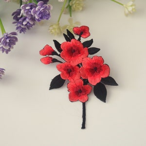 May include: Red embroidered flower patch with black stems and leaves. The patch is perfect for adding a touch of floral detail to clothing, bags, or other crafts.