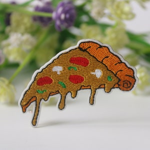 Puede incluir: Un parche bordado para planchar con forma de porción de pizza con pepperoni rojo, pimientos verdes, champiñones blancos y un queso derretido que gotea.