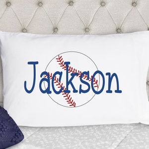 May include: White pillowcase with a blue baseball graphic and the name "Jackson" in blue lettering.