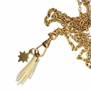 Collar con dije de estrella de nácar tallado a mano en tonos dorados.