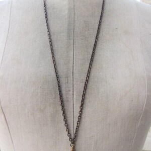 May include: A silver chain necklace with a gold-toned clasp. The chain is a simple, linked design.