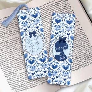 Pode incluir: Dois marcadores de livros azuis e brancos com padrões florais e corações. Um tem o texto "Dearest Gentle Reader", o outro uma silhueta com "Just a girl who loves books".