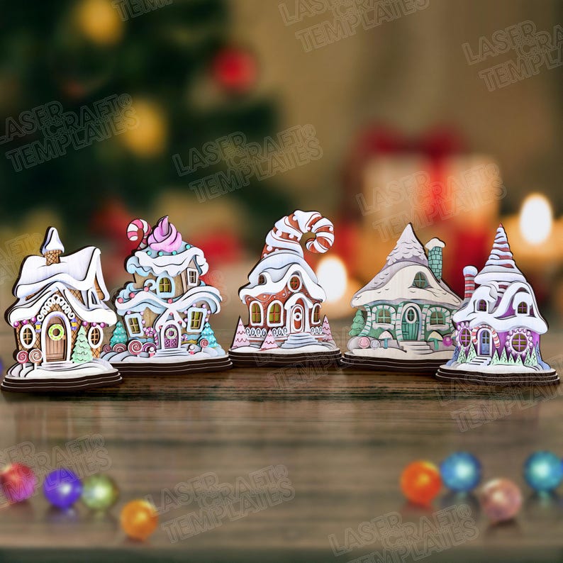 May include: A collection of five wooden Christmas village ornaments. Each ornament is a unique gingerbread house design with colorful details, including snow-covered roofs, candy accents, and decorative doors. The ornaments are set on a wooden surface.