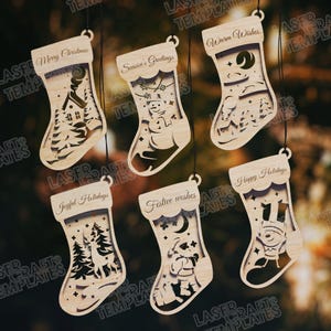 Puede incluir: Una colección de seis adornos de calcetín navideño de madera. Cada adorno presenta un diseño recortado único con temas navideños, incluyendo una casa, un muñeco de nieve y un ciervo. Los adornos tienen texto que dice "Merry Christmas", "Season's Greetings", "Warm Wishes", "Joyful Holidays", "Festive wishes" y "Happy Holidays".