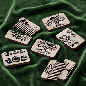 May include: A collection of wooden combs and decorative wooden rectangles with laser-cut designs. The designs include flowers, trees, and leaves. The items are displayed on a green velvet surface.