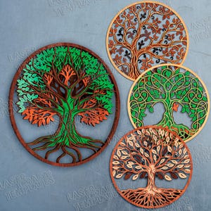 Könnte beinhalten: Vier lasergeschnittene Baumdesigns aus Holz in kreisförmigen Rahmen. Die Bäume weisen komplizierte Details mit grünen, orangefarbenen und braunen Blättern und Ästen auf. Die Designs variieren im Stil.