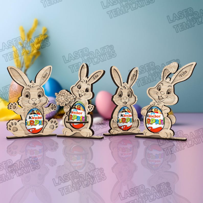 May include: Wooden Easter bunny decorations with Kinder Surprise eggs. Each bunny has a different name engraved on it: Anna, John, Mary, and Peter. The bunnies are on a purple surface with Easter eggs in the background.