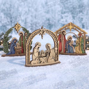 Puede incluir: Tres escenas de nacimiento de madera cortadas con láser. Cada conjunto presenta un arco central, una estrella y figuras que incluyen un infante en un pesebre, con variados detalles decorativos, tonos de madera y acentos pintados en azul, rojo y verde.