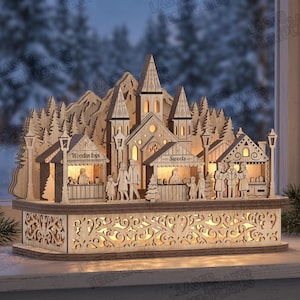 May include: A laser-cut wooden Christmas village display featuring a central church, surrounding stalls labeled "Wooden toys" and "Sweets," and miniature figures. The structure is illuminated from within, set on a decorative base with cut-out patterns.