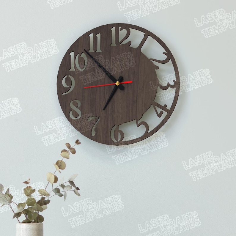 Puede incluir: Un reloj de pared redondo de madera con acabado marr&oacute;n oscuro. El reloj presenta n&uacute;meros recortados y un dise&ntilde;o decorativo en el lado derecho. Las manecillas son negras, con un segundero rojo. El reloj est&aacute; montado en una pared blanca. Di&aacute;metro: aprox. 30 cm.