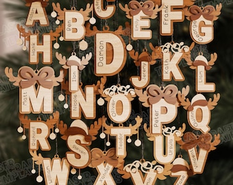 May include: Wooden Christmas ornaments in the shape of letters, each with a name engraved. The letters are decorated with reindeer antlers and bows. The ornaments are hanging against a green background.