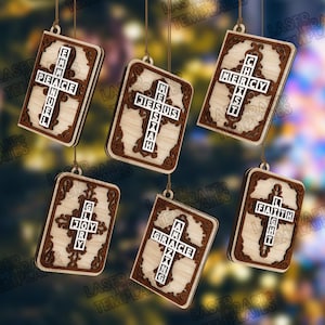 May include: Wooden ornaments with a cross design and religious words. Each ornament has a light wood center with a dark brown border. The words include "Peace", "Jesus", "Mercy", "Joy", "Grace", and "Faith".