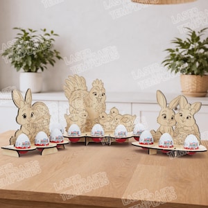 May include: Wooden Easter decorations with bunnies, a hen, chicks, and eggs. The laser-cut designs are arranged on a wooden table, with several chocolate eggs in the foreground. The overall theme is Easter and spring.