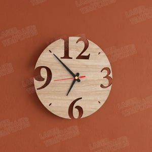 Puede incluir: Un reloj de pared redondo de madera con los n&uacute;meros 3, 6, 9 y 12 recortados. Las manecillas son negras, con un segundero rojo. El reloj est&aacute; montado en una pared marr&oacute;n. El di&aacute;metro del reloj es de aproximadamente 30 cm.