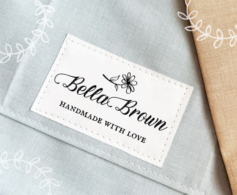 May include: A white label with black text that reads "Bella Brown Handmade with Love". A small flower design is above the text.