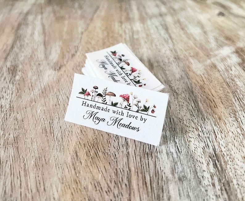 May include: White fabric label with a mushroom illustration and the text "Handmade with love by Maya Meadows".