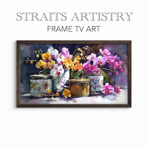 以下が含まれることがあります： 黄色、オレンジ、ピンク、白の色合いの蘭の鮮やかな花の配置が特徴の、額装された水彩画プリント。アートワークには装飾的な瓶とテキスト「STRAITS ARTISTRY FRAME TV ART」が含まれています。