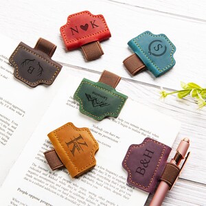 以下が含まれることがあります： 赤、茶色、ティール、緑、オレンジ、紫など、さまざまな色の革製ブックマーク。 各ブックマークはユニークなデザインとゴムバンドが付いています。 イニシャルが入っているものもあります。