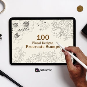 Könnte beinhalten: Ein digitales Tablet zeigt 100 Blumenmuster für Procreate-Stempel an. Das Tablet liegt auf einer weißen Oberfläche mit einem Stift und einer Münze.