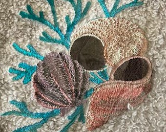 Gant de toilette avec motif coquillages brodés et savon assorti.