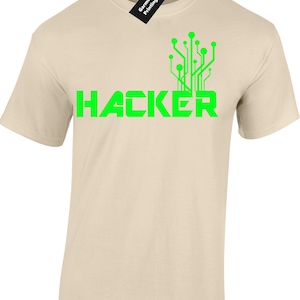 May include: A beige t-shirt with a green graphic of a circuit board and the word "HACKER" printed on the front.