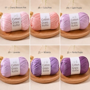 May include: Six skeins of Cotton Grass Rofite yarn in shades of pink and purple, labelled 07 Cherry Blossom Pink, 08 Coral Pink, 09 Light Purple, 10 Lavender, 11 Wisteria, and 12 Perilla Purple. Each ball features a white paper band with text.
